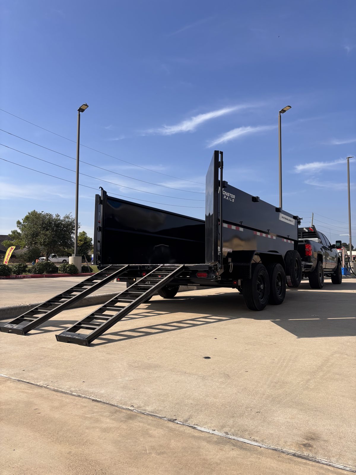 Dump trailer with rear gate open and loading ramps down